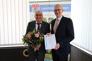 Eckart Bohne (l.) erhielt von Landrat Dr. Heiko Blume nicht nur die Ehrennadel des Landkreises Uelzen in Gold, sondern auch eine Dankurkunde und einen Blumenstrauß