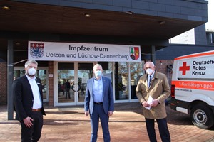 Die Landräte Dr. Heiko Blume (m.) und Jürgen Schulz (r.) freuen sich gemeinam mit Tim Meierhoff vom DRK über den gelungenen Auftakt im Impfzentrum Uelzen