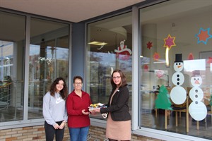 Dezernentin Dr. Julia Baumgarten (r.) dankte den beiden Erzieherinnen Renisa Rusi (l.) und Annette Bleich für die schöne Weihnachtsdekoratio und überreichte unter anderem Süßigkeiten für die Kindergartenkinder